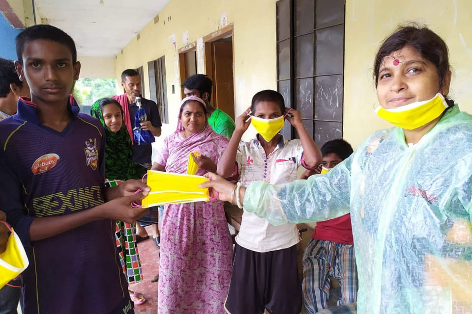 Shampa Goswami (pictured right) and the Prerona team of 15 women and 3 men distribute food packets and masks at cyclone shelters in the wake of cyclone Amphan. Photo: Prerona