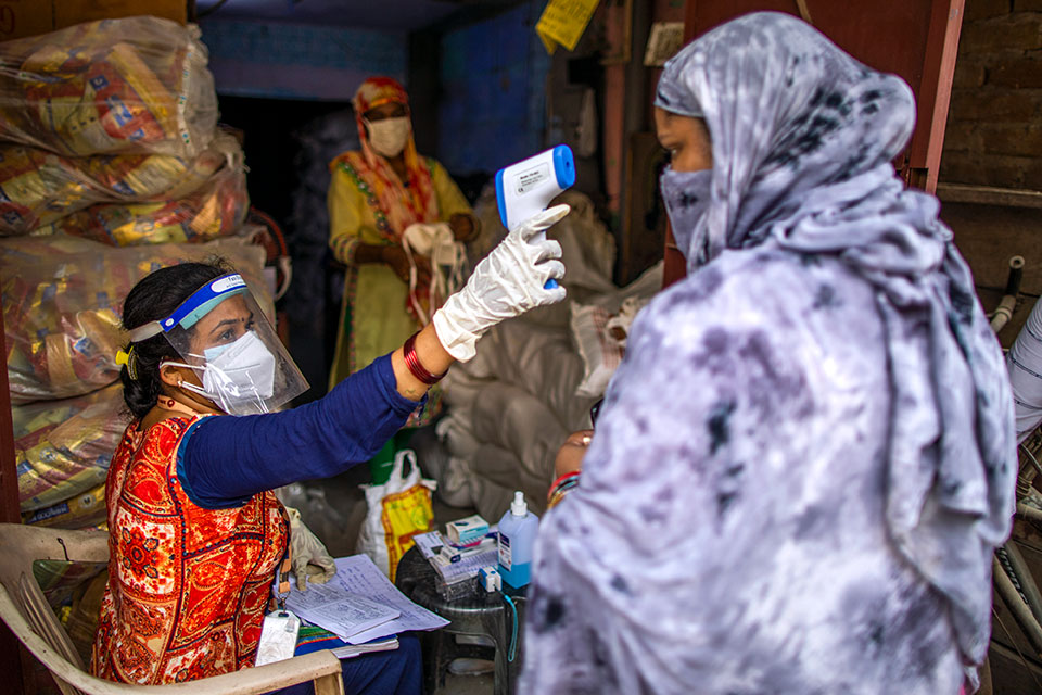 Vandana Gupta, a community worker with SEWA, checking body temperature as part of COVID-19 safety protocols at a ration distribution centre in Jahangir Puri, New Delhi, India. SEWA is a non-governmental organization that organizes and empowers women in the informal economy and home-based workers. SEWA Delhi also provides employment opportunities to home-based workers, education and skills training for women and girls, health clinics and community micro-finance initiatives. UN Women is working with women’s and civil society organizations like SEWA in India to support women and their families during the COVID-19 crisis. UN Women/ Prashanth Vishwanathan