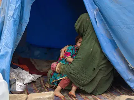 Afghan woman resting with her child. Photo: UN Women/Sayed Habib Bidell