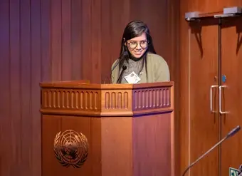 Sushmita S. Preetha speaks at a podium with the United Nations logo