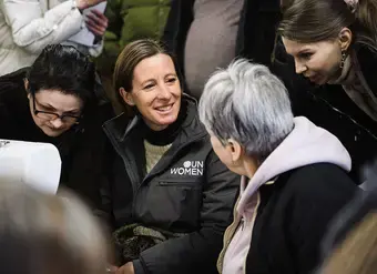 A woman wearing a UN Women jacket sits with Ukranian women