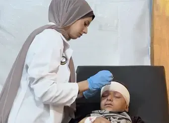 A female medical student treats an injured child in a medical facility in Gaza.