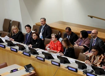 A large panel of speakers in a United Nations conference room