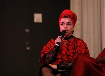 A young woman speaks into a microphone