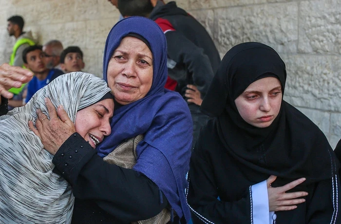 Palestinian women grieve over the bodies of their relatives who were killed in Israeli bombings in Nuseirat and Deir al-Balah, in the central Gaza Strip.