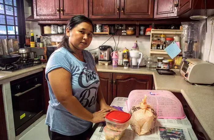 Nurachayatun, una trabajadora del hogar indonesia originaria de Surabaya (Java), prepara alimentos en la cocina de su empleador tras haber hecho la compra a primera hora de la mañana