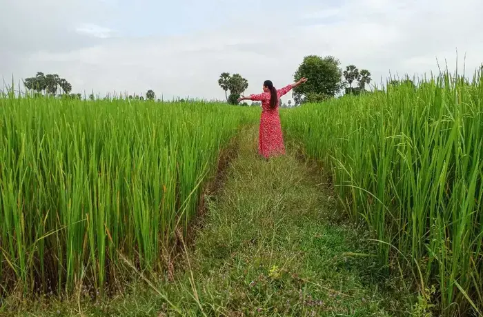 A migrant farmer in Cambodia showing off her rice harvest for a photography project in 2020. Photo: UN Women Cambodia/Women Migrant Workers participatory photography project