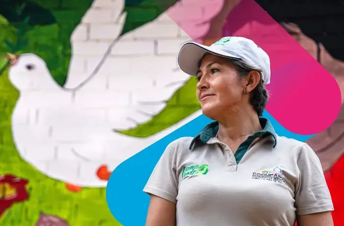 Retrato de mujer con gorra de béisbol con mural de una paloma de la paz al fondo