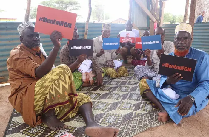 Des hommes brandissent des pancartes contre les MGF lors de sessions de sensibilisation.
