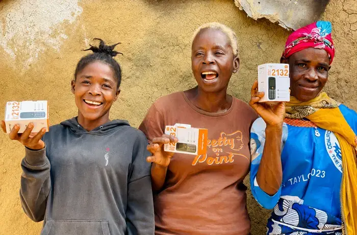 Women from Sargent Kollie Town, Bong County, Liberia, hold mobile phones received through the D4WEE Project, supported by the Orange Foundation. Photo: UN Women/Aisha Kolubah.