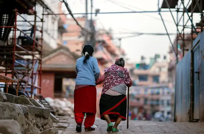 Nepal is part of a growing global movement to transform care systems that work better for women, families, and communities. UN Women’s Transform Care Investment Initiative Asia-Pacific calls for catalytic investments to benefit at least 100 million women and girls and create 125 million new employment opportunities in the care economy by 2035, and reduce women’s unpaid care work. In this photo, a woman assists an older woman walking on the street. Photo: UN Women/Srijana Bhatta