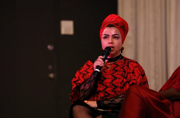 A young woman speaks into a microphone