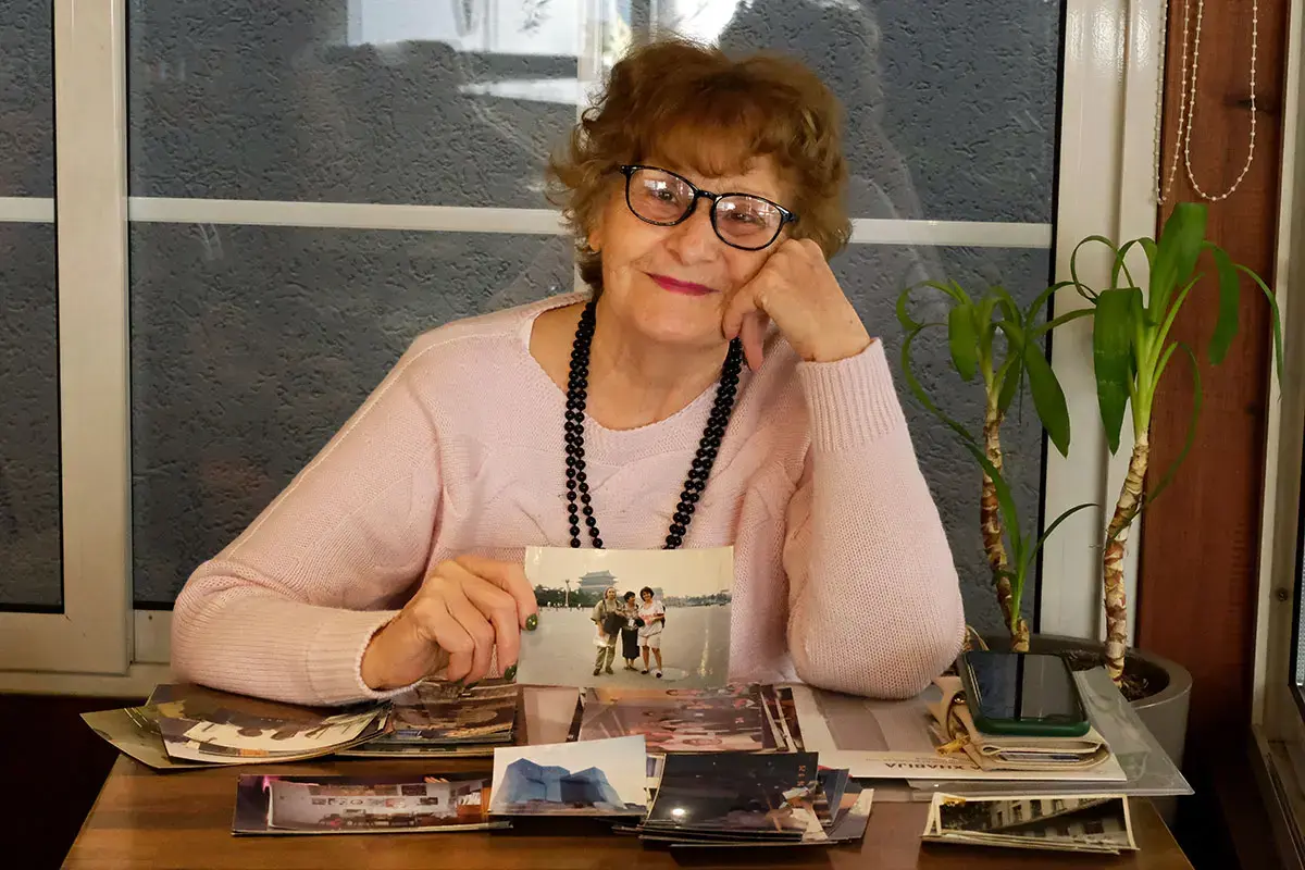 Flutura Xhabija, 76 ans, avec des photographies de sa participation à Beijing en 1995. Photo : ONU Femmes/Yllka Parllaku