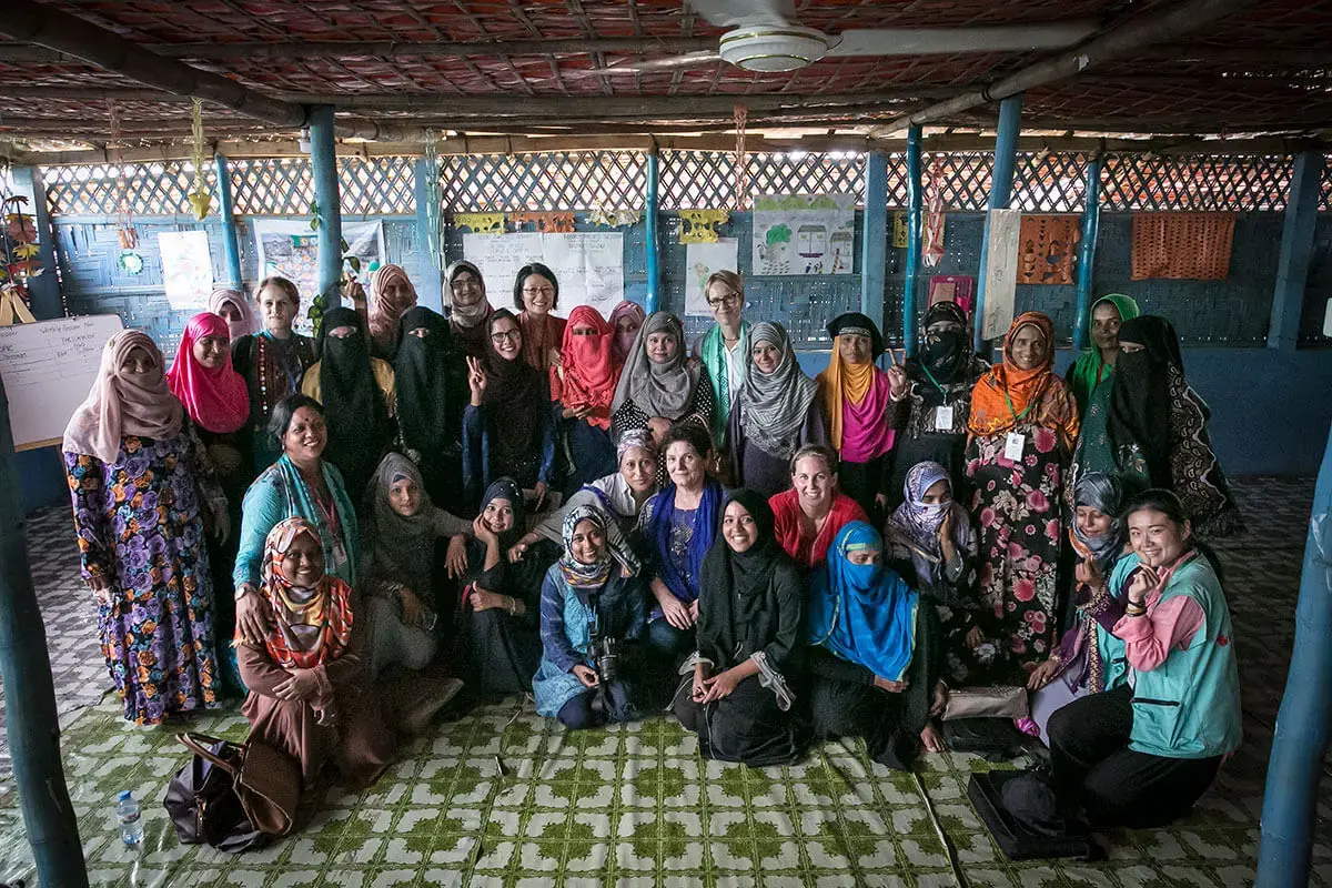 Inside the UN Women multi-purpose women’s centre in refugee camp number 4, UN Women in partnership with Oxfam in Bangladesh, ActionAid Bangladesh, Legal Action Worldwide and RW Welfare Society-RWWS and the UN Resident Coordinator organized a gathering of Rohingya women leaders from new and old camps representing their different women leader networks. Lucky Karim, pictured centre left with glasses giving the peace sign. Photo: UN Women/Allison Joyce.