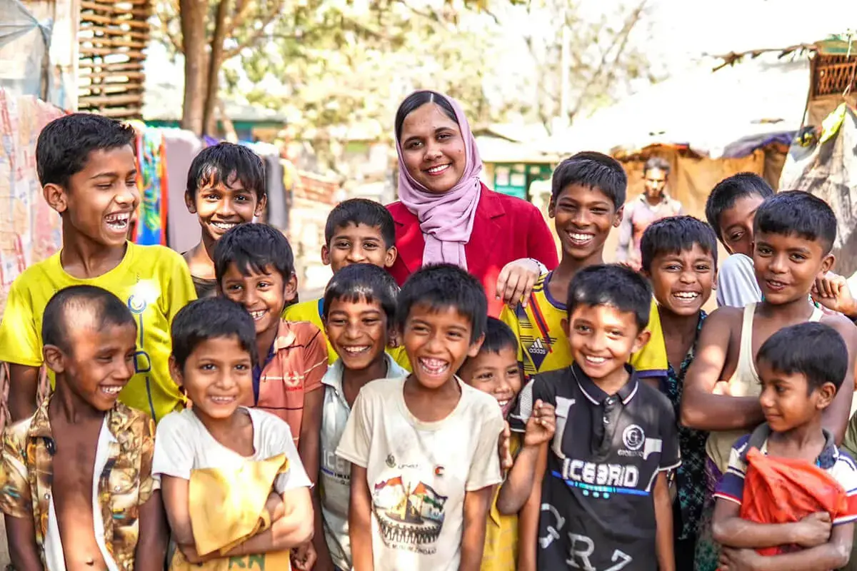 During her return visit to the camps at Cox’s Bazar, kids greet and gather around Lucky Karim. Photo: Refugees International.