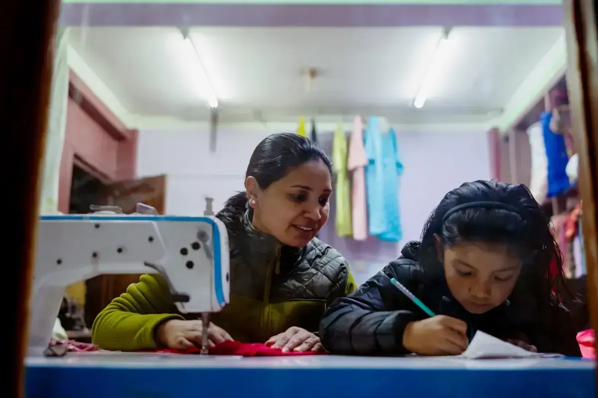 A mother in Nepal works and helps her daughter with her homework. Photo: UN Women/Srijana Bhatta
