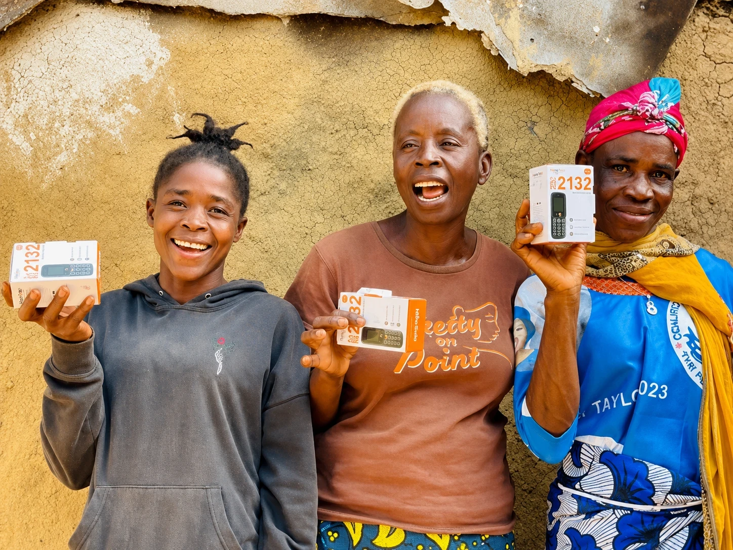 Ma Nowai Kaine (centre) and two other women from Sargent Kollie Town, Bong County, Liberia, hold mobile phones received through the D4WEE Project, implemented by UN Women with support from the Orange Foundation. Photo: UN Women/Aisha Kolubah.