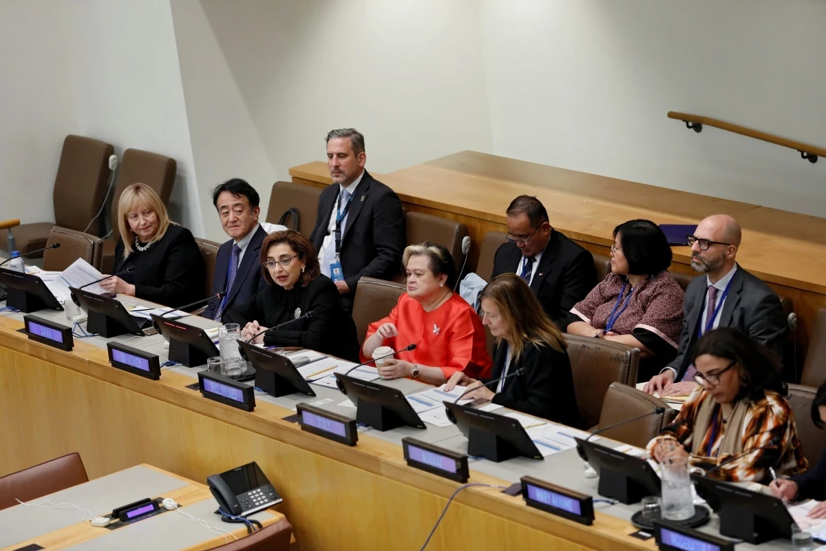 A large panel of speakers in a United Nations conference room