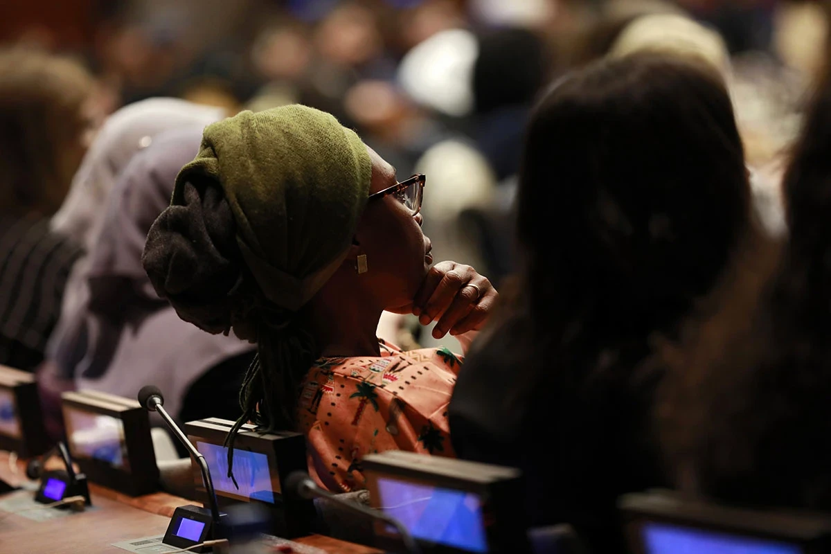A woman listens closely to a speaker at the UN