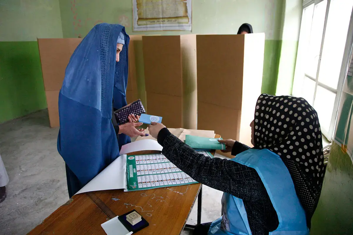 A woman electoral officer and a woman voter at a polling station in Kabul participate in Presidential and Provincial Council elections on 5 April 2014 - an important step forward in their country’s first democratic transition of power. Photo: UN Photo/Fardin Waezi