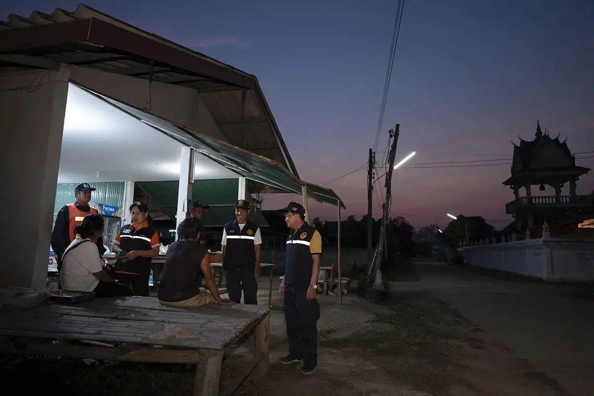 (second from left) volunteers in her village as part of a nighttime safetypatrol — seeking to offer safety and reassurance to neighbors under the stars. 11March 2025, Chiang Khong District, Chiang Rai Province. 