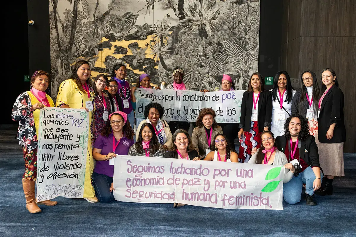 Grupo de unas veinte mujeres con pancartas pidiendo una paz inclusiva.