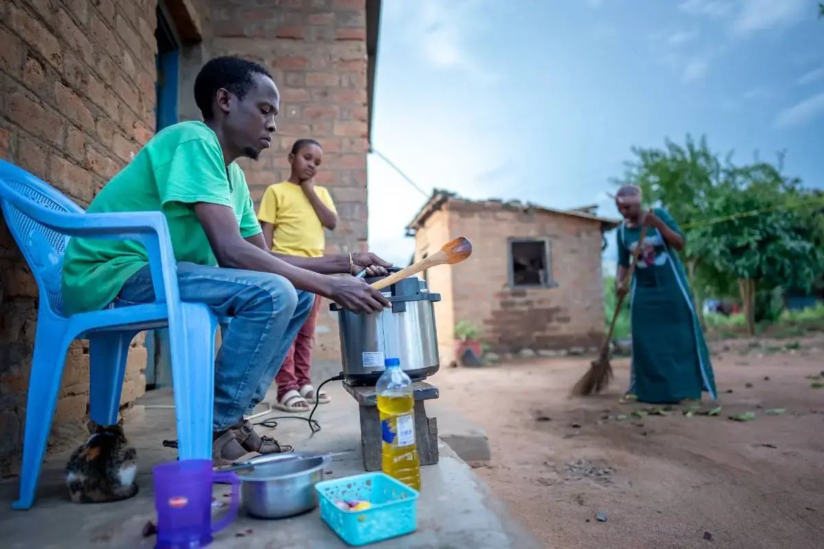 A father from the Singida, Tanzania, region cooks with his family. 